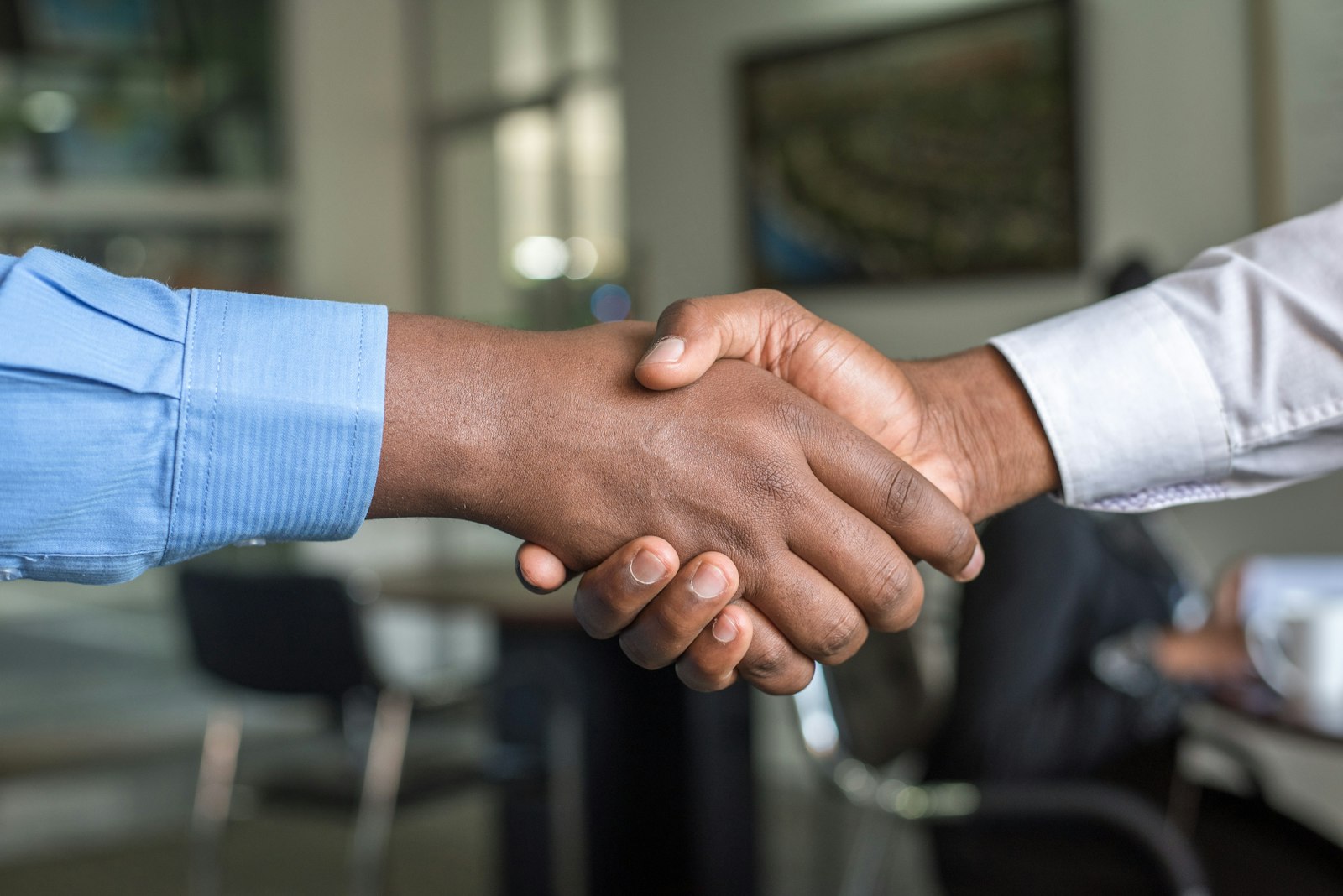 Insurance agent shaking hands with a client in an office
